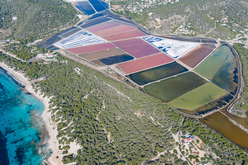 Luftaufnahme der Salinenfelder im Naturpark Ses Salines bei Es Cavallet mit farbigen Salzbecken und Küstenlinie