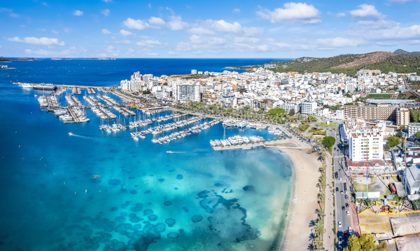 Luftaufnahme des Hafens von Sant Antoni de Portmany mit Marina, Strand und Stadtbebauung an der Bucht