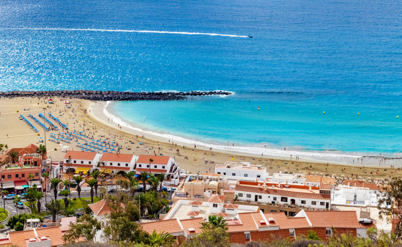Teneriffa - Playa de Los Cristianos Playa de las Vistas in Los Cristianos, Teneriffa: breiter heller Sandstrand mit Liegen, ruhigem Wasser und Promenade vor dem Ferienort.