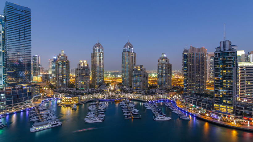 Dubai Marina bei Nacht mit beleuchteter Skyline und Yachthafen