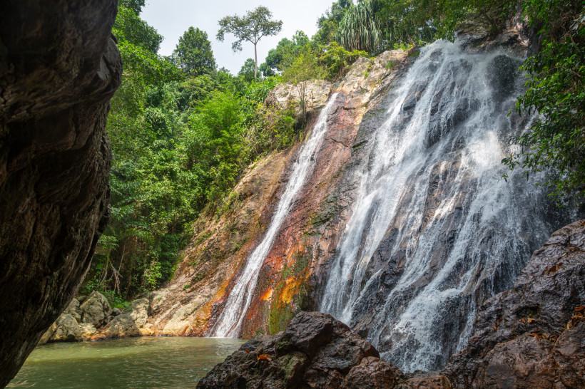 Na Muang 1 Wasserfall auf Koh Samui: 18 Meter hoher Wasserfall mit Naturpool, umgeben von dichtem Regenwald und Felsen.