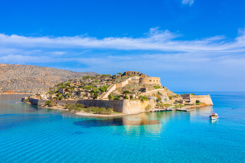 Inselfestung Spinalonga vor der Küste Kretas Inselfestung Spinalonga mit Mauern und Ruinen am Ufer des türkisfarbenen Meeres