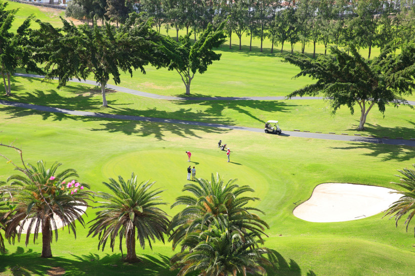 Blick auf den Golfplatz Maspalomas Golf mit Putting-Green, Palmen und Sandbunker