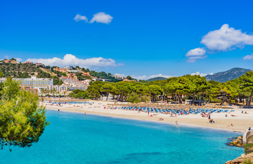 Strandbucht von Santa Ponsa mit flachem Ufer, Sonnenschirmen und Hotels am Hang