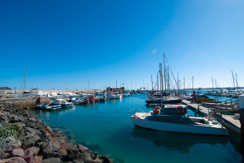 Hafen von Corralejo mit Liegeplätzen, Segelbooten und Motorbooten im ruhigen Wasser
