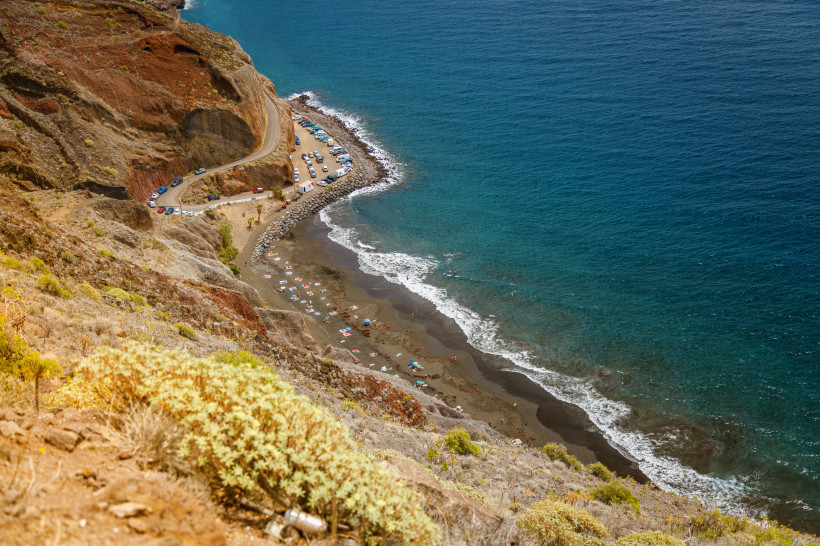 Teneriffa - Playa de Las Gaviotas abgelegener Naturstrand mit dunklem Sand, umgeben von Felsen und Meer, erreichbar per Boot oder Wanderung.