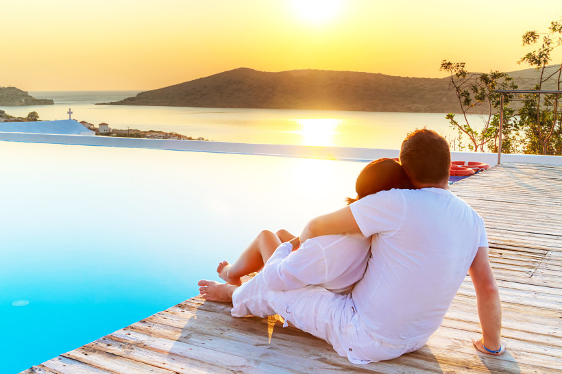 Mirabello-Bucht: Paar am Pooldeck bei Sonnenuntergang Paar sitzt am Pooldeck und blickt bei Sonnenuntergang über die Mirabello-Bucht
