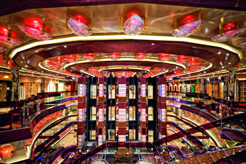 Costa Fascinosa – Atrio Amarcord mit Glasaufzügen und mehrstöckigen Galerien Atrio Amarcord auf der Costa Fascinosa mit mehrstöckigem Lichthof, Glasaufzügen und roter Deckenbeleuchtung