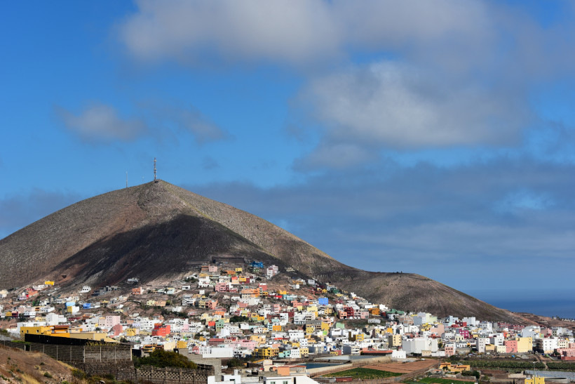 Gáldar – farbenfrohe Häuser am Berghang auf Gran Canaria Bunte Häuser von Gáldar auf Gran Canaria liegen am Fuße eines kahlen Vulkanhügels. Der blaue Himmel und die markante Hügellandschaft verleihen dem Ort ein typisch kanarisches Flair.
