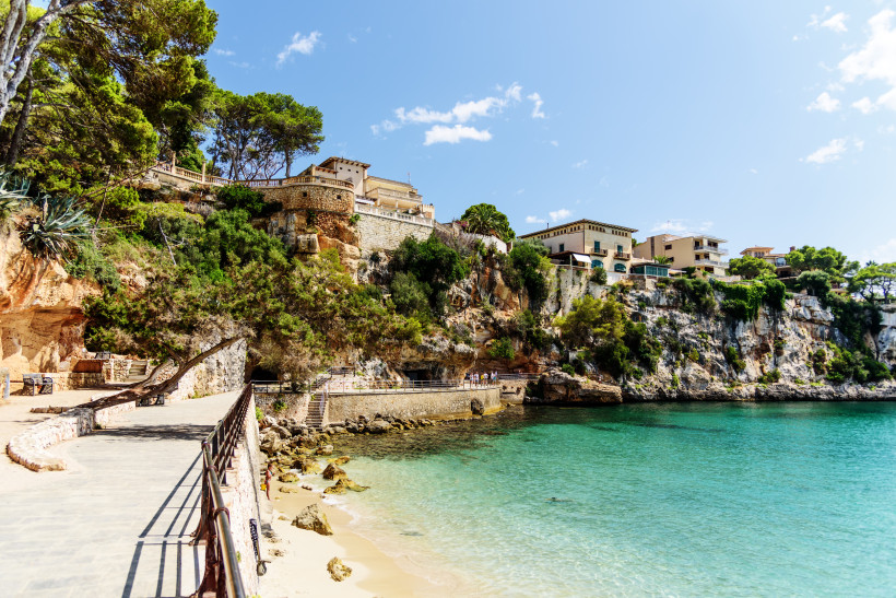 Porto Cristo, Mallorca Felsenpromenade an der Cala Marçal auf Mallorca mit türkisfarbenem Wasser und Häusern auf den Klippen