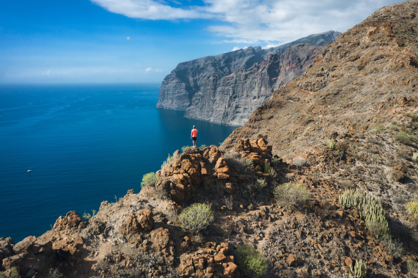 Wanderer blickt auf die beeindruckenden Steilklippen von Los Gigantes auf Teneriffa mit Blick auf den Atlantik