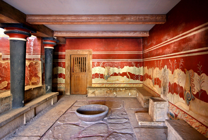 Innenraum im Palast von Knossos mit roten Wandmalereien, Säulen und steinernem Becken