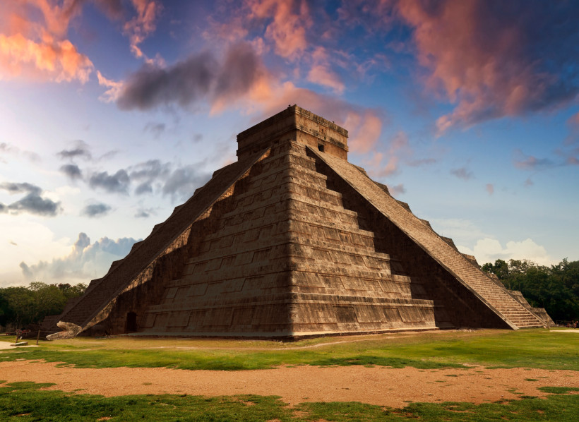 Die beeindruckende Pyramide von Chichén Itzá, eines der bekanntesten Wahrzeichen der Maya-Kultur, aufgenommen bei einem atemberaubenden Sonnenuntergang. Diese archäologische Stätte auf der Halbinsel Yucatán in Mexiko zählt zu den neuen sieben Weltwundern 