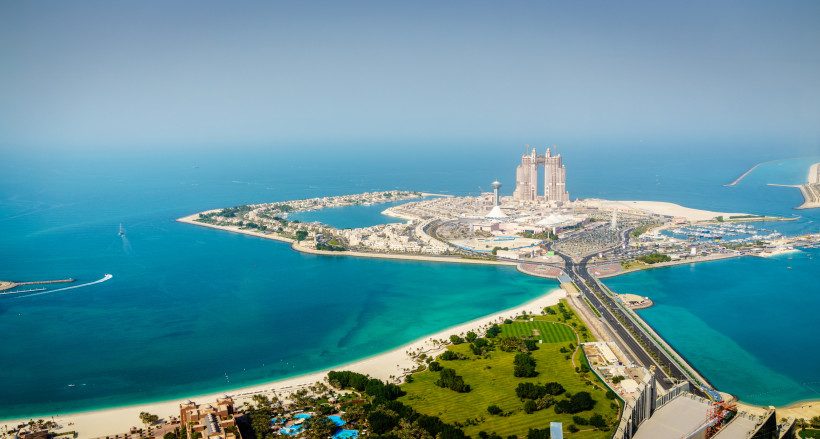 Abu Dhabi Luftaufnahme der Insel Abu Dhabi mit türkisfarbenem Wasser, modernen Hochhäusern und einer Brücke, die die Insel mit dem Festland verbindet