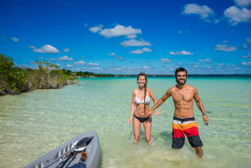 Schönes verliebtes Paar beim Kajakfahren auf dem ruhigen Bacalar-See.