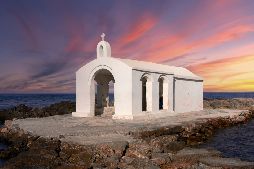 Kapelle an der Küste von Georgioupolis bei Abendstimmung Weiße Kapelle am Meer bei Sonnenuntergang in Georgioupolis