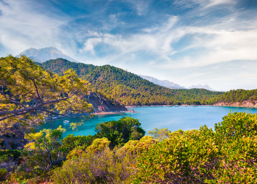 Naturbucht bei Tekirova an der Türkischen Riviera mit türkisblauem Meer, Pinienwäldern und dem Taurusgebirge im Hintergrund