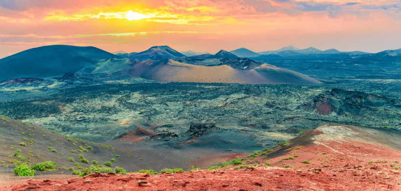 Timanfaya Feuerberge – Panorama über die vulkanische Landschaft Lanzarotes Panoramablick auf die Feuerberge im Timanfaya Nationalpark auf Lanzarote mit bunten Vulkankratern und Lavafeldern.