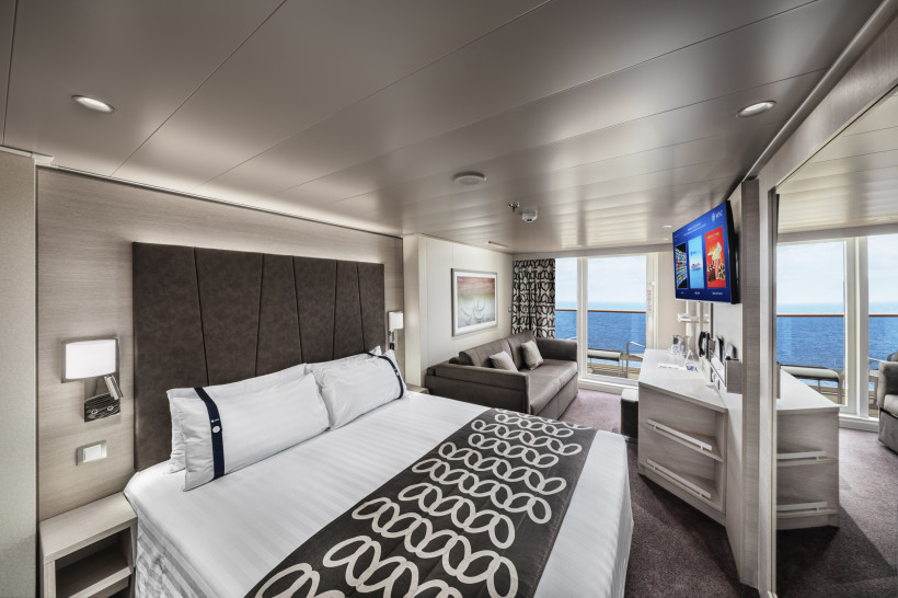Kabine Deluxe Balcony Aurea (BA) auf der MSC Euribia mit Doppelbett, Sofa, Fernseher und Balkon mit Meerblick