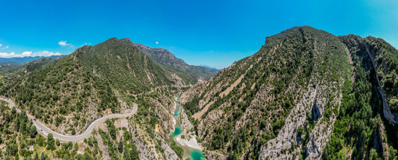 Gebirgstal in den Pyrenäen in Spanien mit Flusslauf zwischen bewaldeten Berghängen