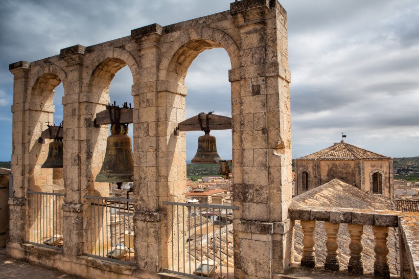 Noto – historische Glocken und barocke Architektur auf Sizilien Blick auf die alten Glocken und Steinbögen einer Barockkirche in Noto, Sizilien – eindrucksvolle Architektur und historische Atmosphäre in der UNESCO-Weltkulturerbestadt