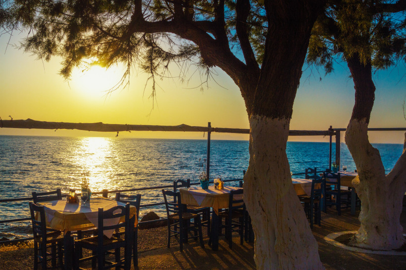 Taverne auf Kreta   Blick auf die Tische in der Taverne am Meer bei Sonnenuntergang
