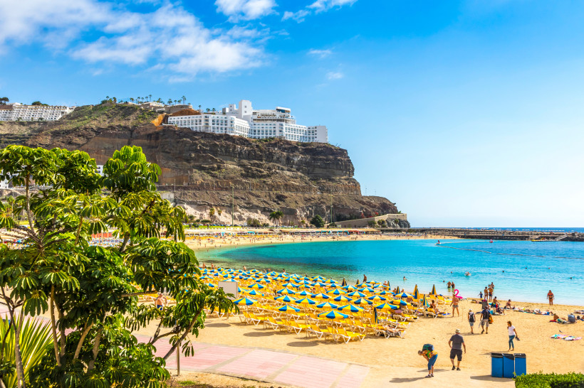 Playa de Amadores – Entspannter Badeurlaub auf Gran Canaria mit Sonne, Strand und Meer Goldene Sandstrand Playa de Amadores mit gelben Liegestühlen und türkisfarbenem Meer auf Gran Canaria