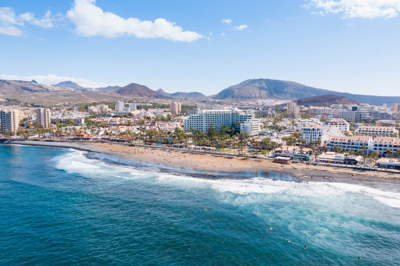 Luftaufnahme von Playa de las Américas auf Teneriffa mit Strand, Hotels und Bergen im Hintergrund