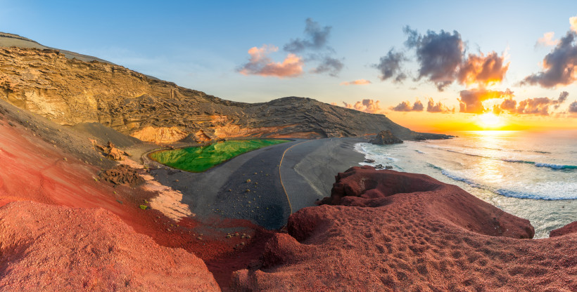 Lanzarote - Yaiza Panoramablick auf den grünen El Golfo Kratersee auf Lanzarote mit schwarzem Strand, rotem Lavagestein und Sonnenuntergang am Atlantik.