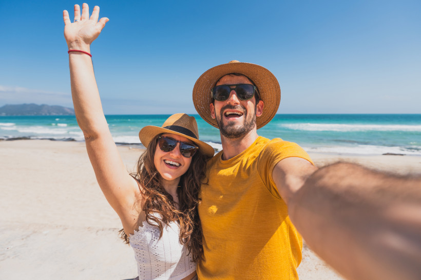 Paar am Sandstrand von Can Picafort mit Blick auf Meer und Bucht von Alcúdia