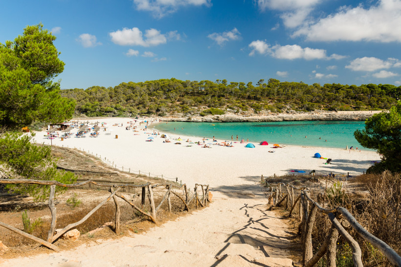 Cala s’Amarador und Cala Mondragó: Sandstrand, türkisfarbenes Meer und Pinienbewuchs Blick über einen Sandstrand mit türkisfarbenem Wasser und Pinienwald bei Cala s’Amarador und Cala Mondragó