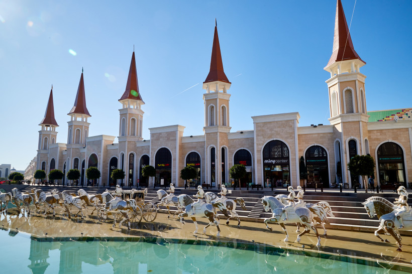 The Land of Legends Shopping Avenue – exklusives Einkaufserlebnis in Belek Eingangsbereich der The Land of Legends Shopping Avenue in Belek mit imposanten Türmen, Boutiquen und dekorativen Pferdeskulpturen am Wasserbecken.
