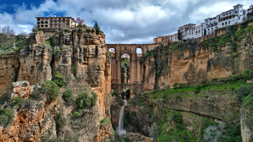 Puente Nuevo in Ronda über der Schlucht El Tajo mit Wasserfall und Häusern auf den Felsen