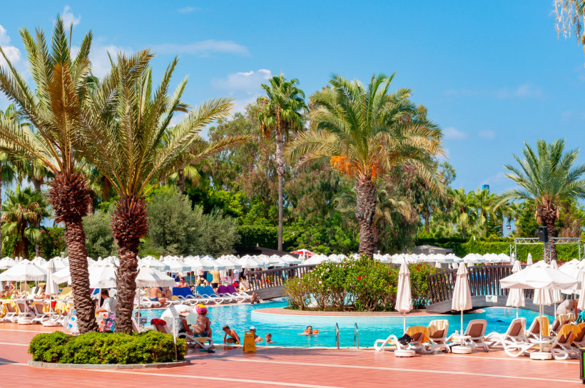Belek günstig entdecken – Preiswerte Hotels mit Pool und tollen Annehmlichkeiten Poolanlage eines Hotels in Belek mit Palmen und Sonnenliegen – ideal für einen preiswerten Badeurlaub