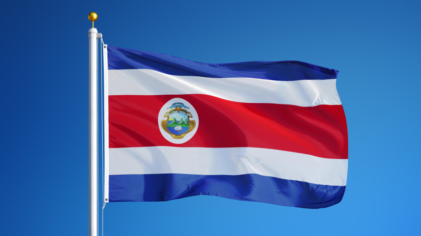 Juan Santamaria Day, Costa Rica Die Nationalflagge von Costa Rica weht vor einem klaren, blauen Himmel. Die Flagge zeigt horizontale Streifen in Blau, Weiß, Rot, Weiß und Blau mit dem Wappen in der Mitte des roten Streifens