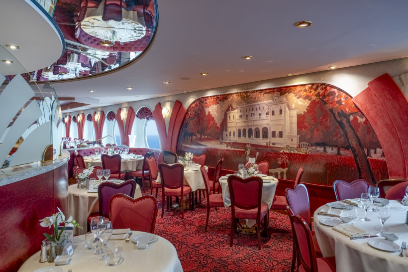 Restaurant Villa Borghese auf der MSC Orchestra mit gedeckten Tischen, roten Stühlen und Wandgemälde