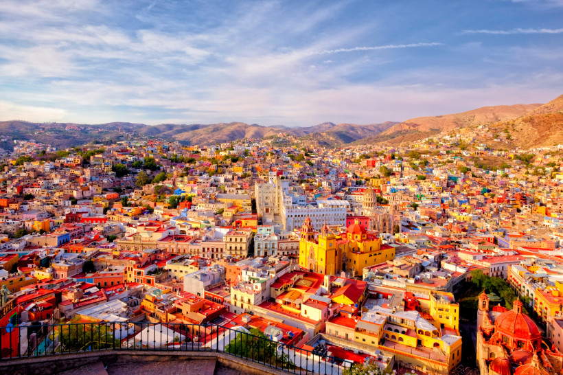 Festival Cervantino in Guanajuato Panoramablick auf die farbenfrohen Häuser und historischen Gebäude von Guanajuato, Mexiko, umgeben von Hügeln unter einem blauen Himmel
