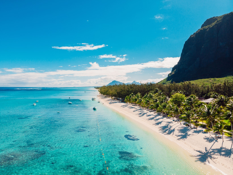 Mauritius Ein paradiesisches Reiseziel: Feinster Sand, sanftes Meeresrauschen und majestätische Berge im Hintergrund – der perfekte Ort zum Träumen und Entspannen.