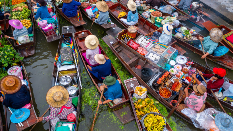 Damnoen Saduak Floating Market – Bunte Händlerboote im lebendigen Marktkanal Luftaufnahme der bunten Händlerboote mit Obst, Gemüse und Streetfood auf dem Damnoen Saduak Floating Market in Thailand.