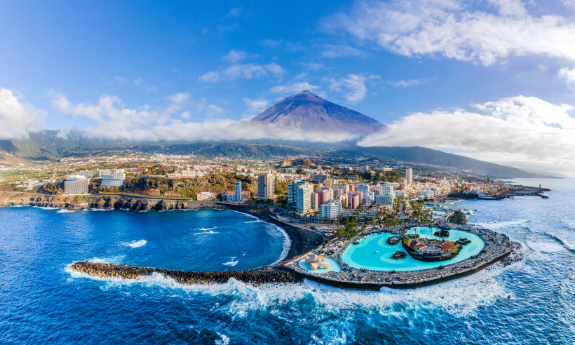 Luftaufnahme von Puerto de la Cruz auf Teneriffa mit Küste, Meerwasser-Schwimmbad Lago Martiánez und dem Teide im Hintergrund