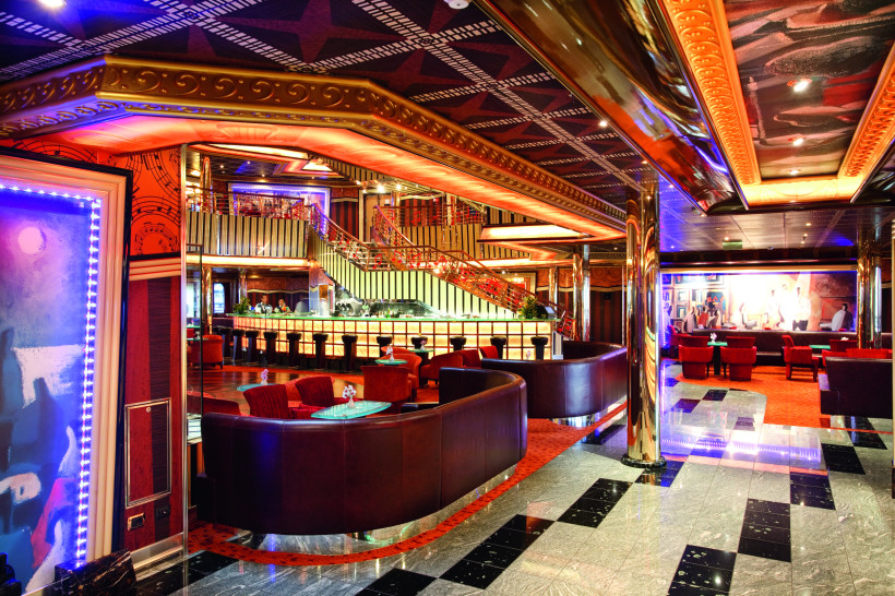Costa Pacifica: stilvolle Lounge mit Barbereich und Live-Musik Lounge auf der Costa Pacifica mit Bar, Sitzgruppen und farbiger Beleuchtung