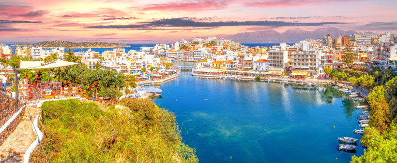 Hafenansicht von Agios Nikolaos auf Kreta Blick auf den Hafen von Agios Nikolaos mit Uferpromenade und Gebäuden am Wasser bei Abendlicht