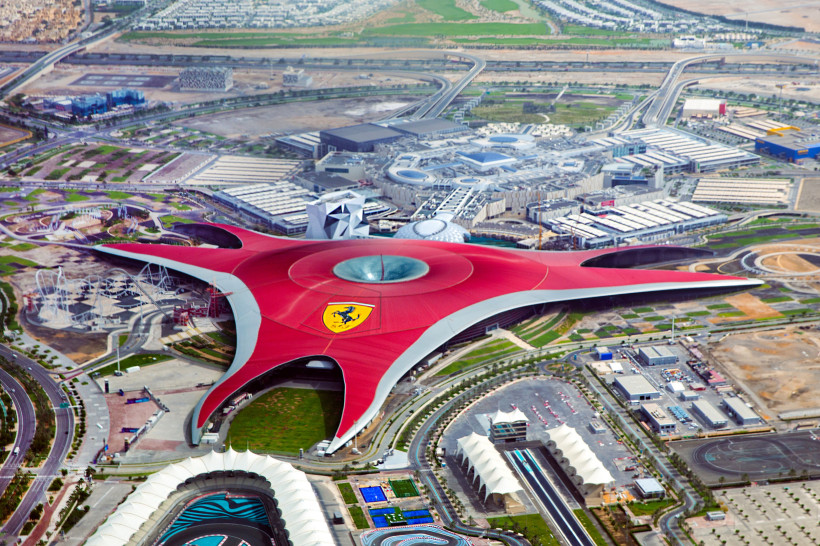 Luftaufnahme von Ferrari World Abu Dhabi mit dem ikonischen roten Dach in Form eines dreizackigen Sterns und dem Ferrari-Logo