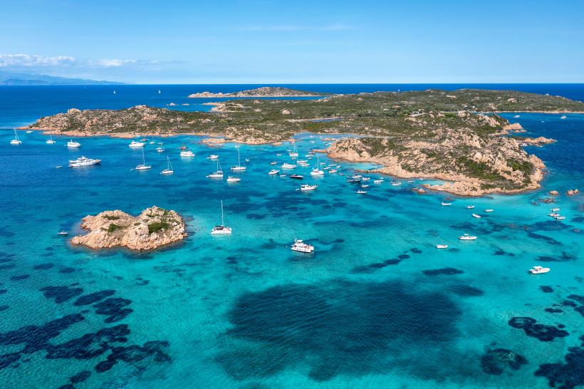 Luftaufnahme des La-Maddalena-Archipels auf Sardinien mit Yachten in türkisfarbenen Buchten und felsiger Küstenlandschaft im Mittelmeer