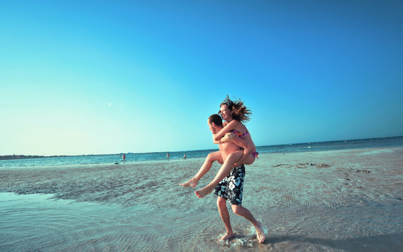 Paar genießt entspannten Moment am Strand bei sonnigem Wetter