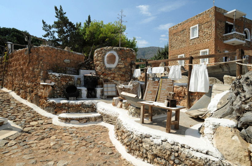 Lychnostatis Freilichtmuseum: Hofszene mit Steinbauten, Waschplatz und Wäscheleine Außenbereich im Lychnostatis Freilichtmuseum mit Natursteinmauern, Waschplatz und Wäscheleine mit weißen Textilien