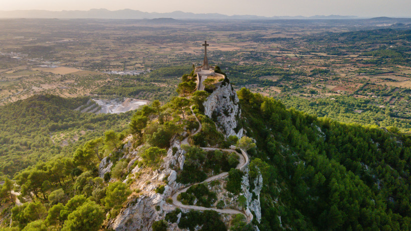 Aussichtspunkt am Santuari de Sant Salvador mit Kreuz auf einem Felsgrat über dem Tal