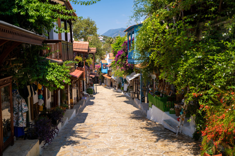 Türkei - Kas  Romantische Altstadtgasse in Kas mit kleinen Geschäften, Balkonen und blühenden Bougainvilleen