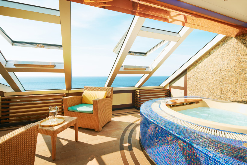 Wellnessbereich der Costa Favolosa: Whirlpool mit Sitzbereich und Blick aufs Meer Whirlpoolbereich im Wellnessbereich der Costa Favolosa mit Liegesitzen und Meerblick durch große Panoramafenster