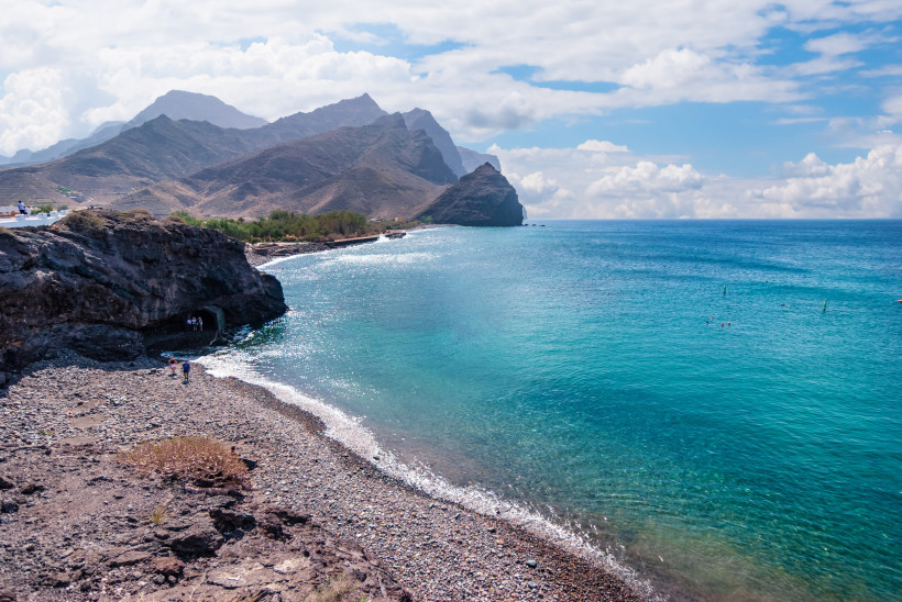 Dramatische Steilküste im Westen Gran Canarias – Playa de La Aldea Kiesstrand Playa de La Aldea im Westen Gran Canarias mit türkisblauem Meer und steiler Felsküste.